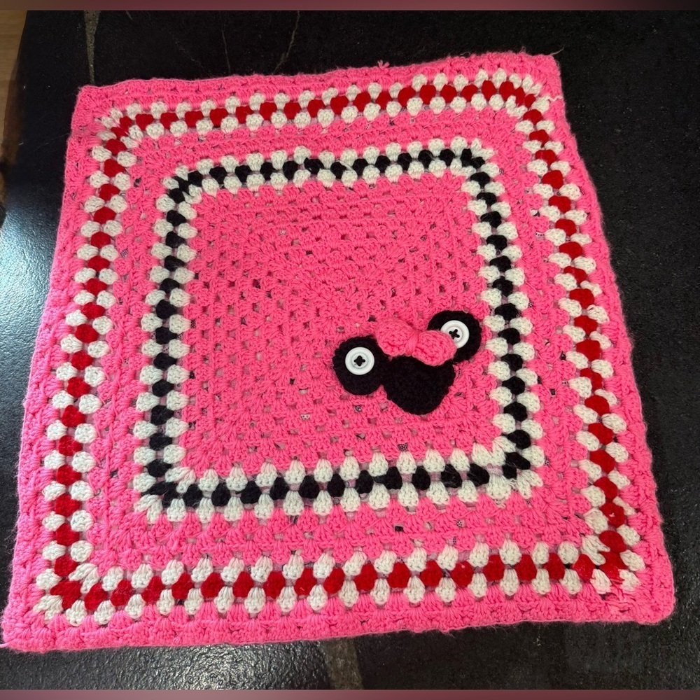 This is a handmade crocheted Minnie Mouse granny square blanket.